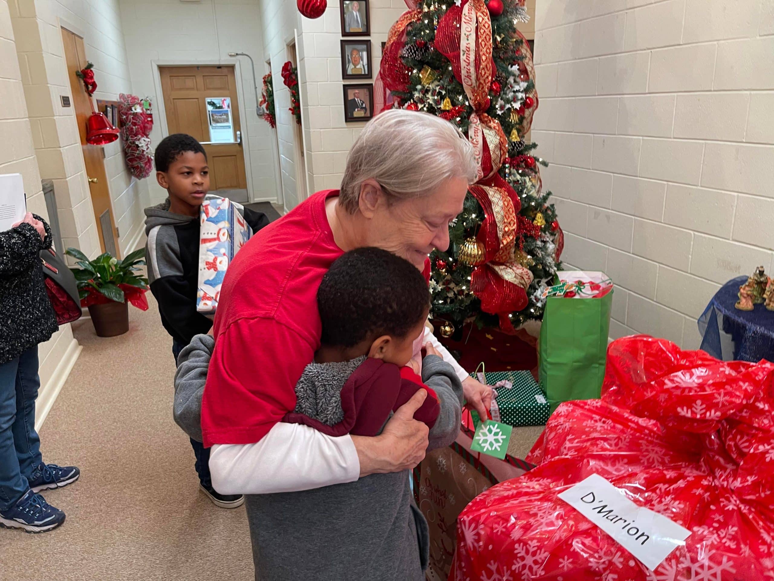 Thieda Edwards embracing a child during the Christmas gift giveaway at Homewood Baptist Church, Alexandria. Brian Blackwell photo