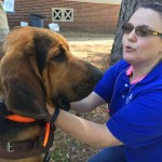 A library staff member pets a dog at the Paws Up event at Louisiana College.