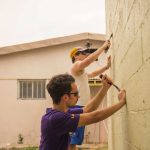 Students paint a building during a mission trip to Mexico.