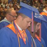 A student prays before commencement begins.