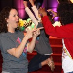 Adult leaders cut up during a large group game time.