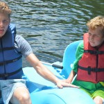 A buddy with his Champions Camp participant tackle a ride on the paddle boat.