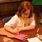 During craft time at Champions Camp, a girl works on her project.