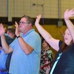 Attendees of the Tomorrow's Hope Crusade lift their hands toward heaven.