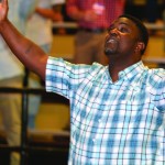 A man at the Tomorrow's Hope Crusade lifts his hands toward heaven.