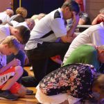 Attendees of the Tomorrow's Hope Crusade kneel down in prayer for those who do not know Christ.