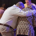 Attendees of the Tomorrow's Hope Crusade kneel down in prayer for those who do not know Christ.