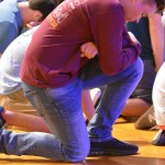 Attendees of the Tomorrow's Hope Crusade kneel down in prayer for those who do not know Christ.