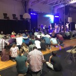 Several hundred people kneel down in prayer for those who are lost.