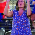 A woman raises her hands during a time of worship.