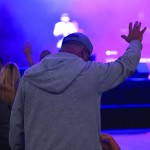 A man raises his hands during a time of worship.