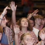 Students lift their hands in praise during a time of worship at the Tomorrow's Hope GO TELL Crusade. Doug Collier photo