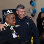 A law enforcement officer shares a laugh with a special guest at Night to Shine in Gonzales.