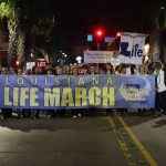 Louisiana Life March Southwest participants carry a banner.
