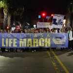 Louisiana Life March Southwest participants carry a banner.