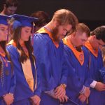 Students prayed moments before receiving their diplomas during a special commencement service for 13 athletes unable to attend regularly scheduled commencement ceremonies. Brian Blackwell photo