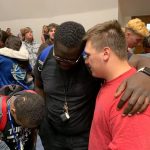 A Louisiana College staff member prayed with students at the close of the first day of the campus revival.