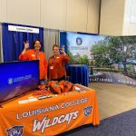 Louisiana College staff prepare to welcome alumni and friends at their booth inside the SBC exhibit hall.