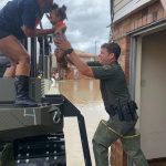 A Louisiana Department of Wildlife and Fisheries Agent handed off a baby to a passenger in a truck. LDWF photo