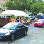 Illinois and Missouri Baptist Disaster Relief feeding team members distributed meals to a line of vehicles at First Baptist Church in Mandeville.