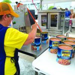 An Oklahoma Baptist Disaster Relief team member opens cans of food at Bayou Vista Baptist Church in Morgan City. Brian Blackwell photo