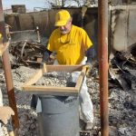 A Louisiana Baptist DR team member sifted through items covered in ash.