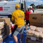 Rolling Hills feeding unit team members unload supplies under a tent at First Baptist Church, Naples, Florida.
