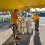 Rolling Hills feeding unit team members unload supplies under a tent at First Baptist Church, Naples, Florida.