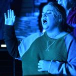 A student participates in a time of worship at YEC.