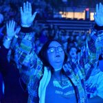 A student participates in a time of worship at YEC.