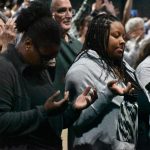 Women lifted their hands in prayer during the Big Creek Baptist Association Revival.