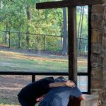 Two campers kneeled before the cross and said a prayer during the three-day Champions Camp at Tall Timbers. Submitted photo