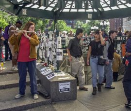 A woman plays a hymn on her flute outside a New York City subway entrance in the days following the attack on the World Trade Center. Photo by Jim Veneman